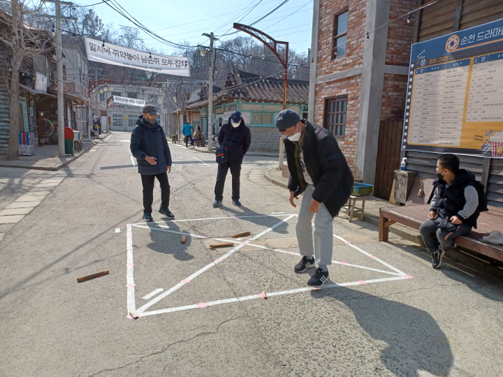 순천 드라마 촬영지안에서 전통놀이를 체험하고 있는 이용인들의 모습