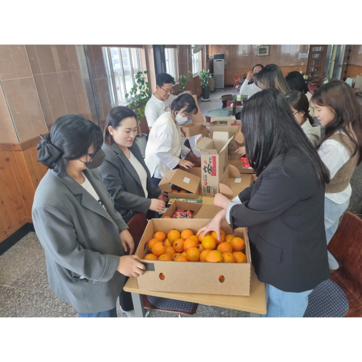 라면과 오렌지 등 식품을 소포장하는 봉사활동에 참여하고 있는 아라마크 회원들의 모습입니다