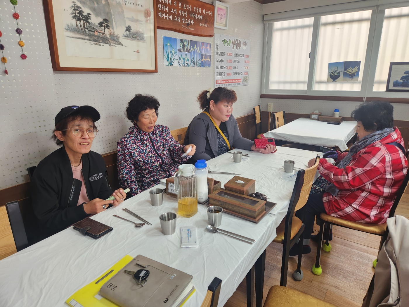 자조모임에 참여하는 재가장애인 4명이 함께 식당에 앉아 식사를 준비하고 있는 사진입니다. 