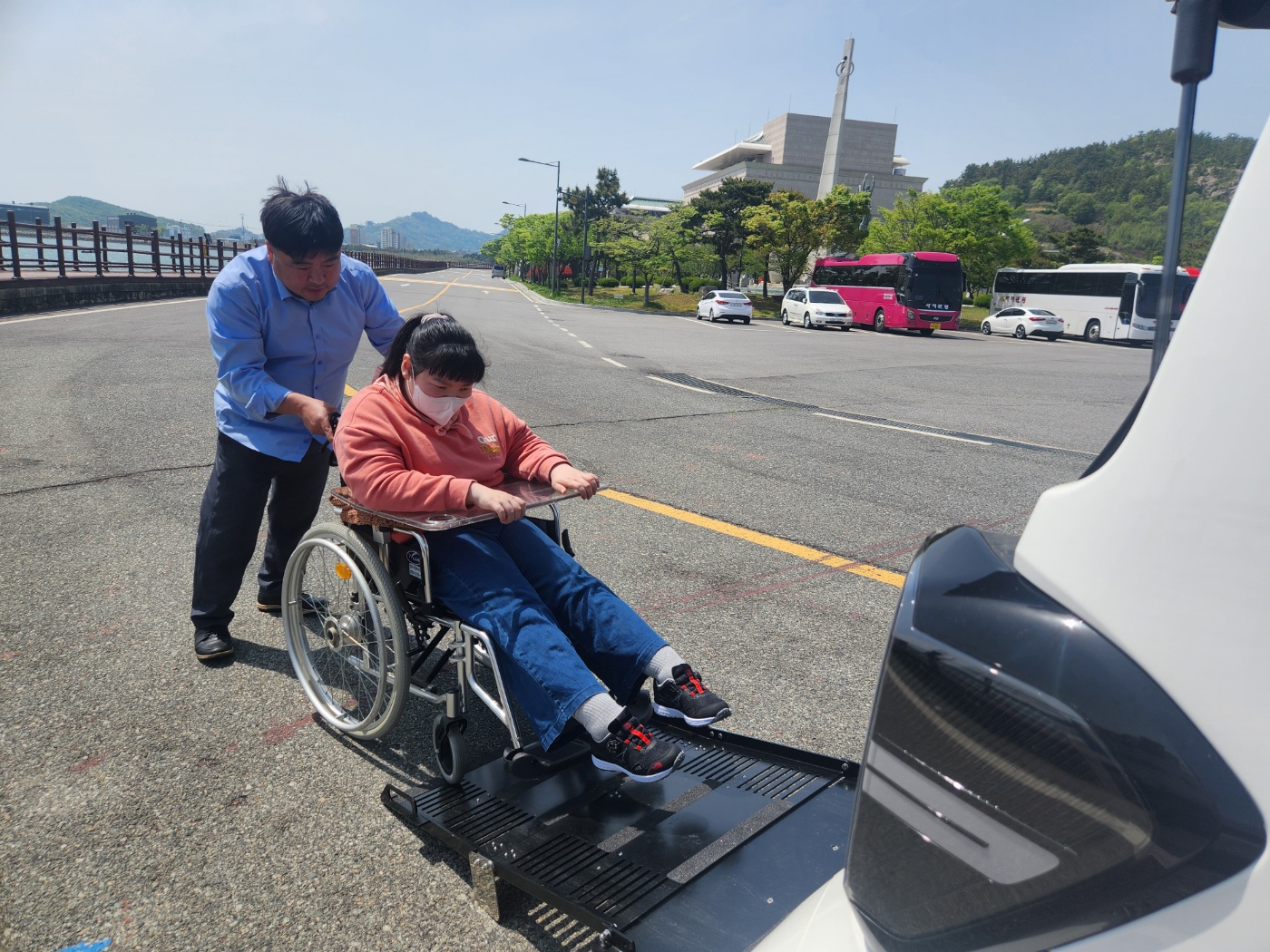 리프크카에 휠체어를 탄 이용인을 태우는 담당 사회복지사의 사진입니다. 