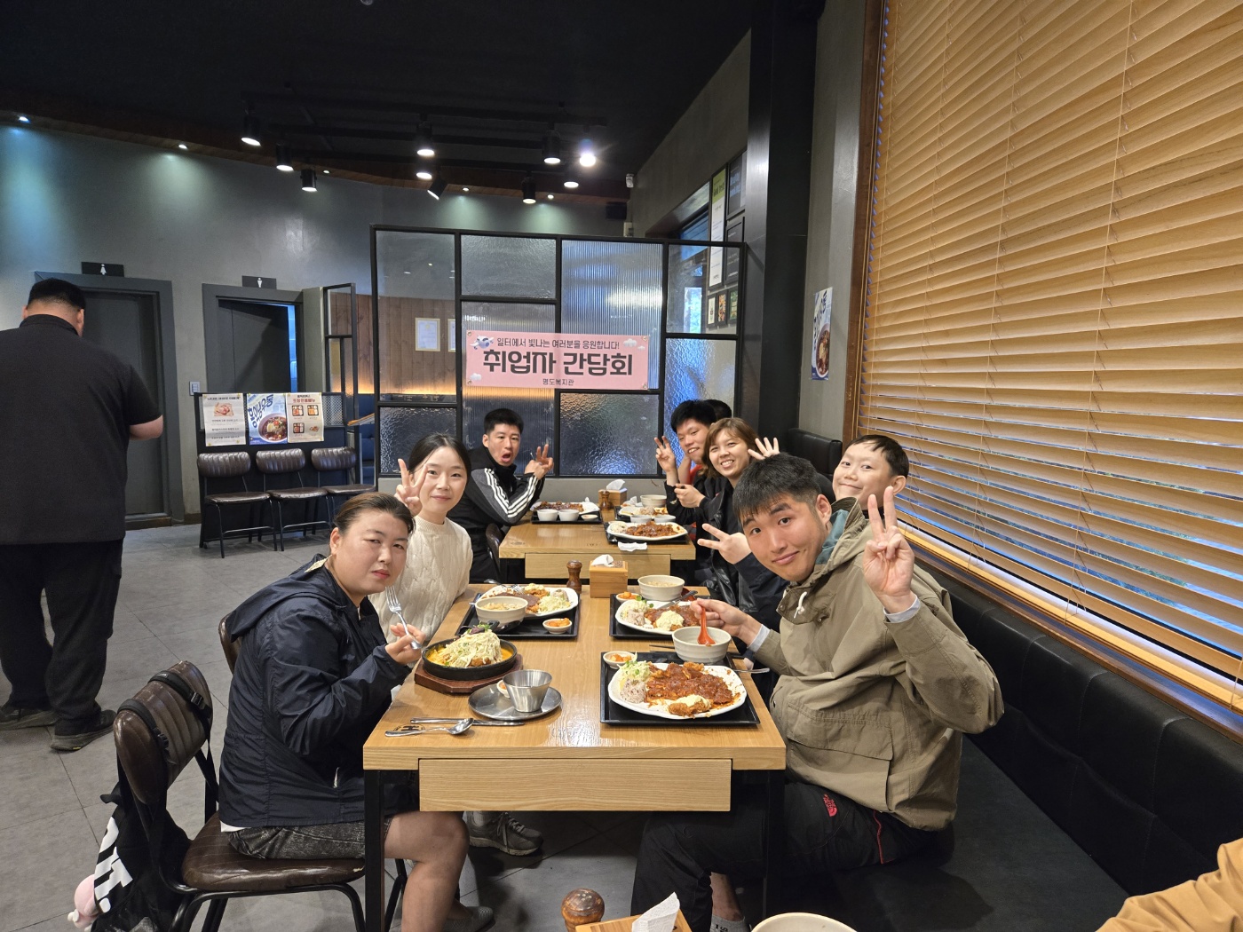 식당에 모여 식사를 하던 중, 카메라를 응시하며 함께 찍은 단체사진입니다. 