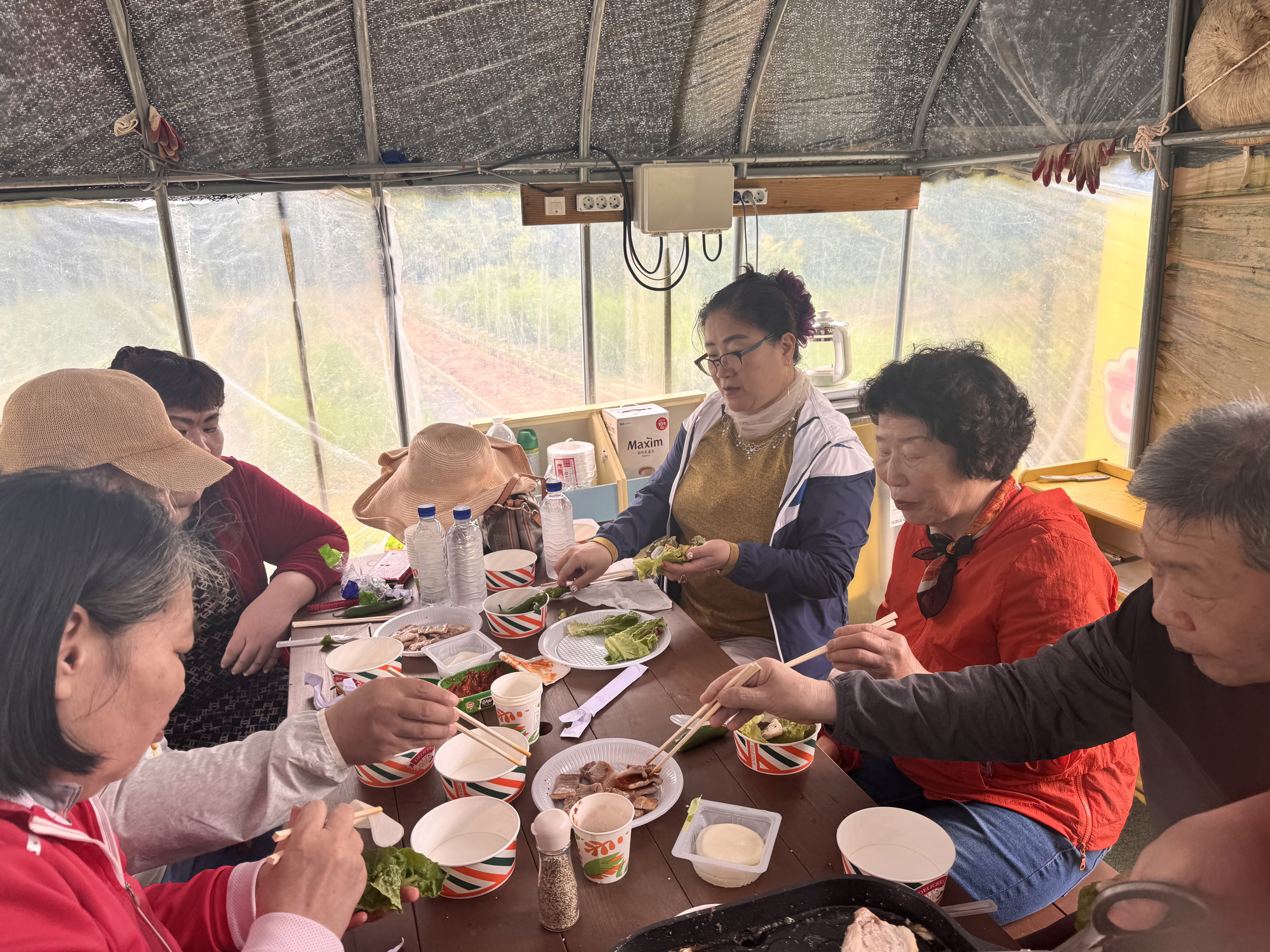 주말농장에 있는 비닐하우스 안에서 식사를 맛있게 하고 있는 재가장애인분들의 모습입니다.