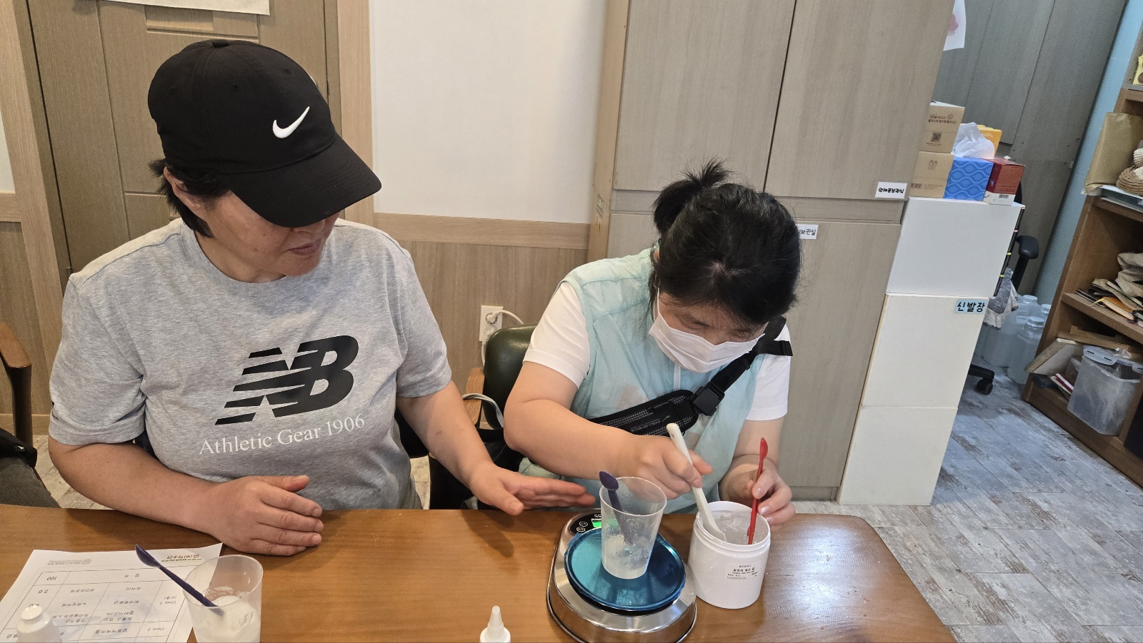 모녀가 집중해서 화장품을 만들고 있는 모습입니다. 