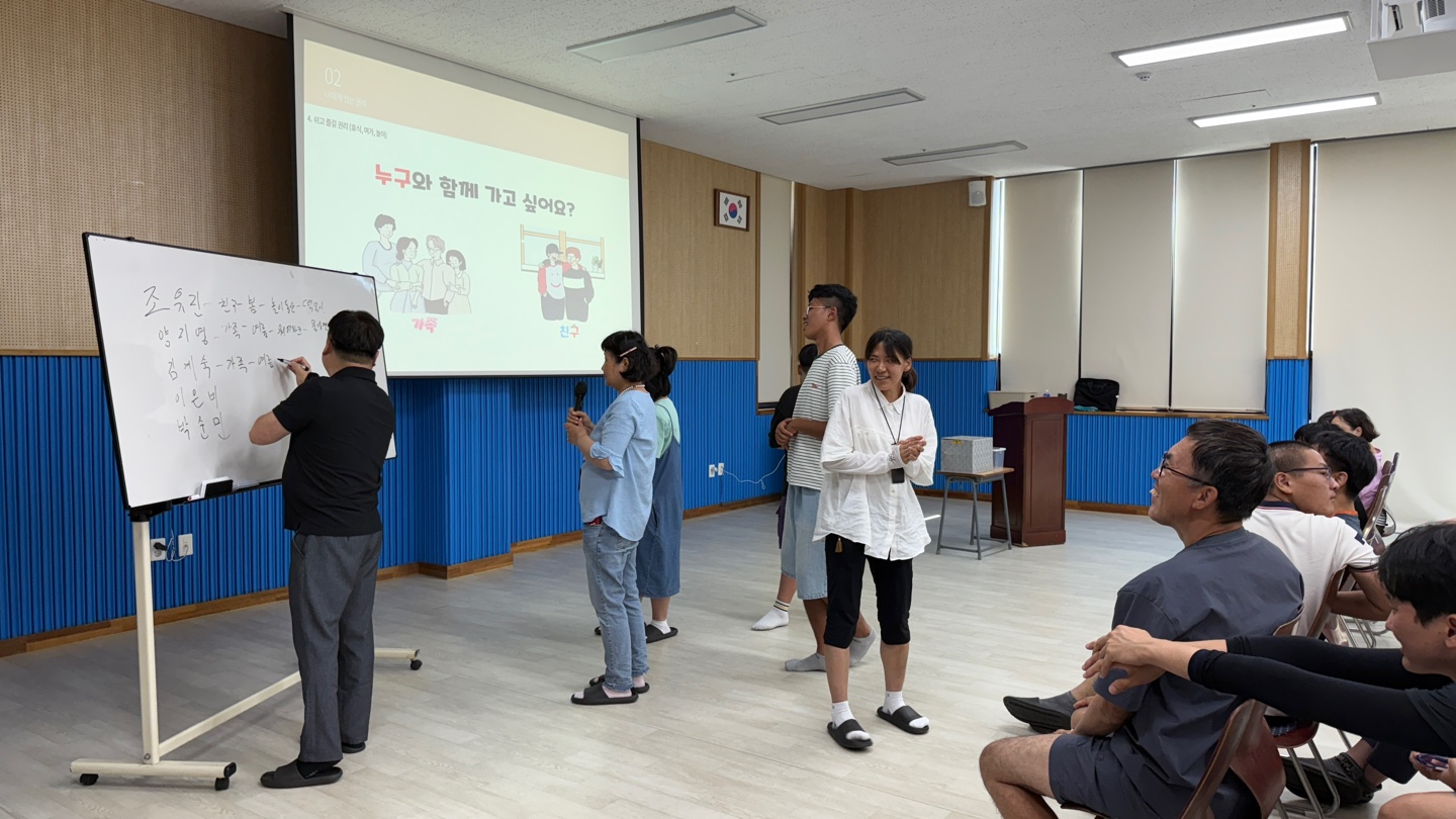 이용인들이 앞으로 나가 강사님과 칠판에 글을 적으로 활동에 적극적으로 참여하고 있는 모습의 사진입니다. 