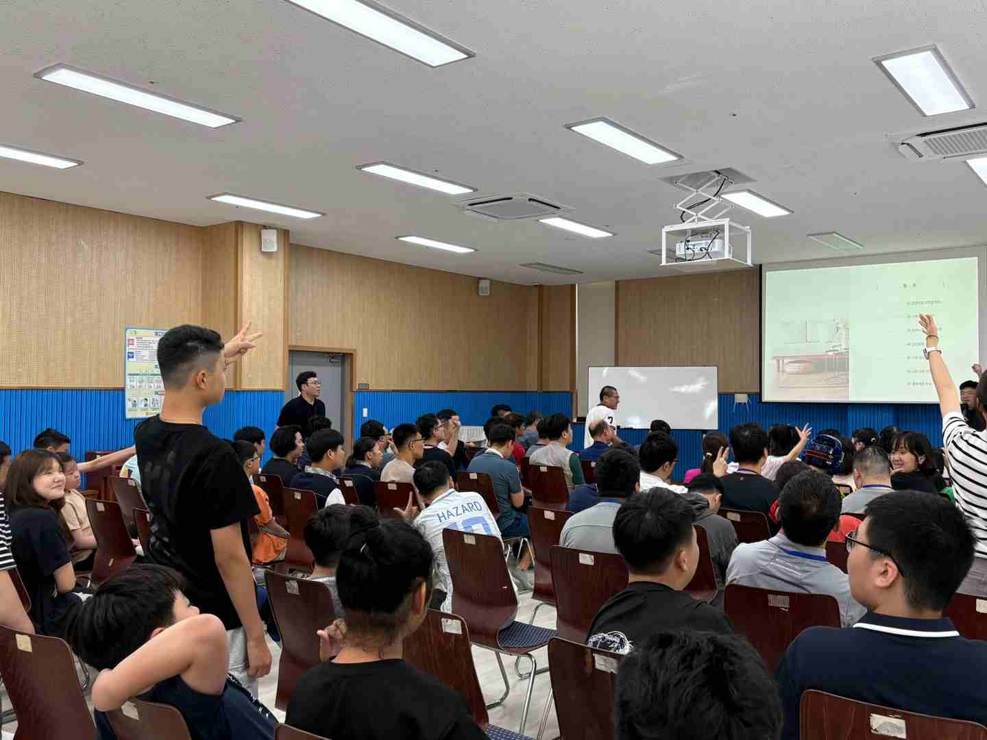 자리에 앉아 강사님과 함께 단체 가위바위보를 하고 있는 사진입니다. 