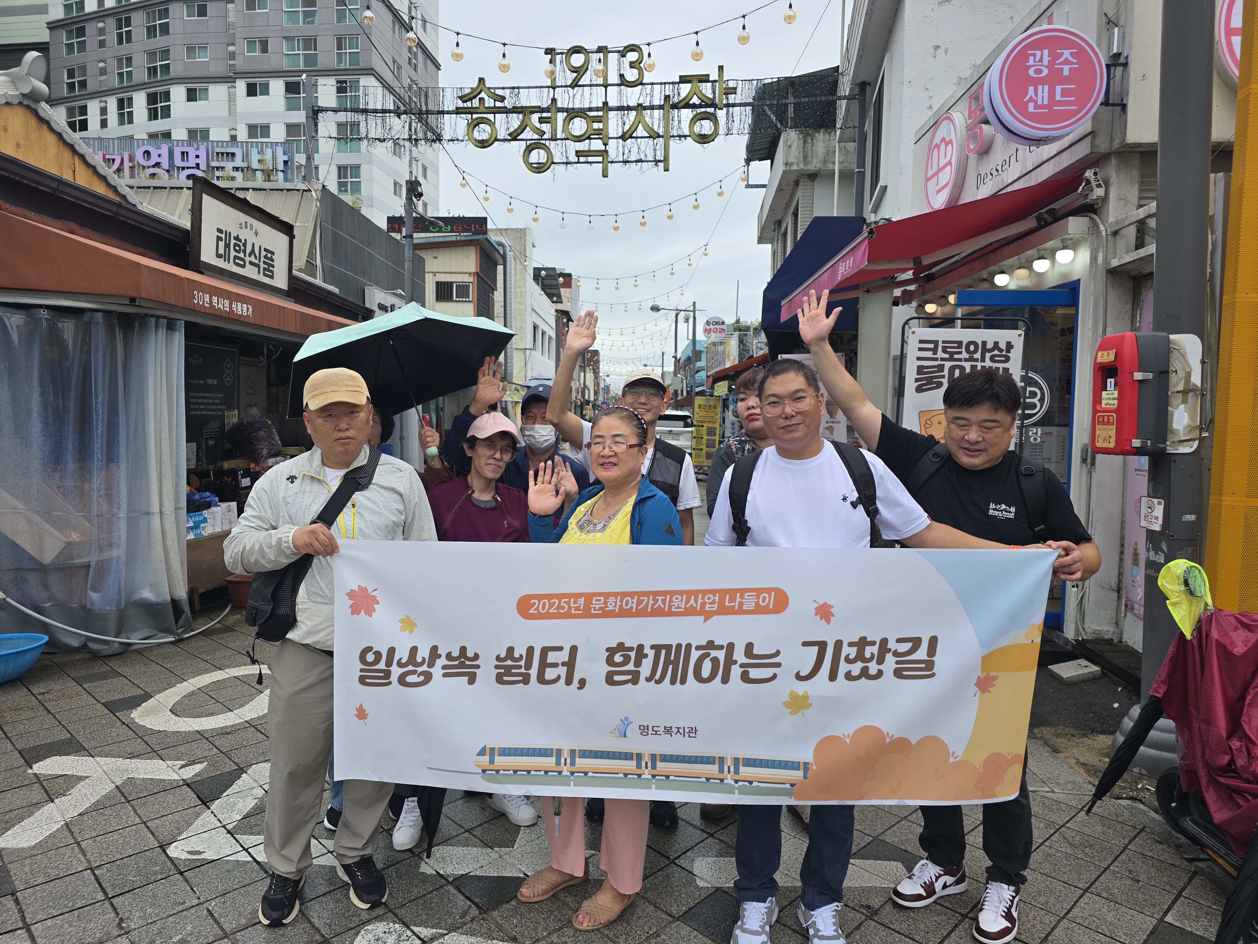 송정역시장에서 나들이 현수막을 들고 다함께 찍은 단체사진입니다.