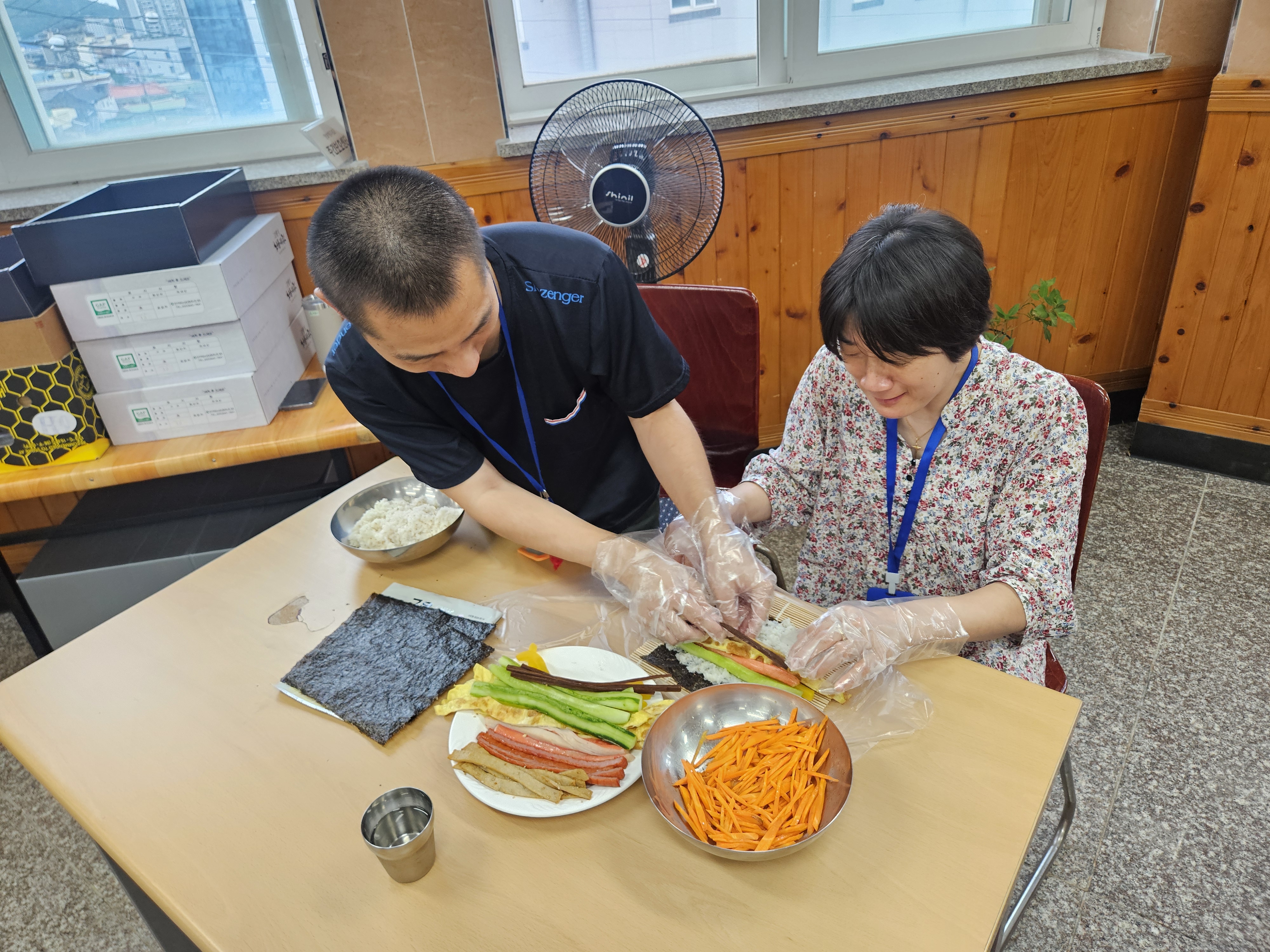 참여자들 간 서로 도와가며 김밥을 싸고 있는 모습의 사진입니다. 