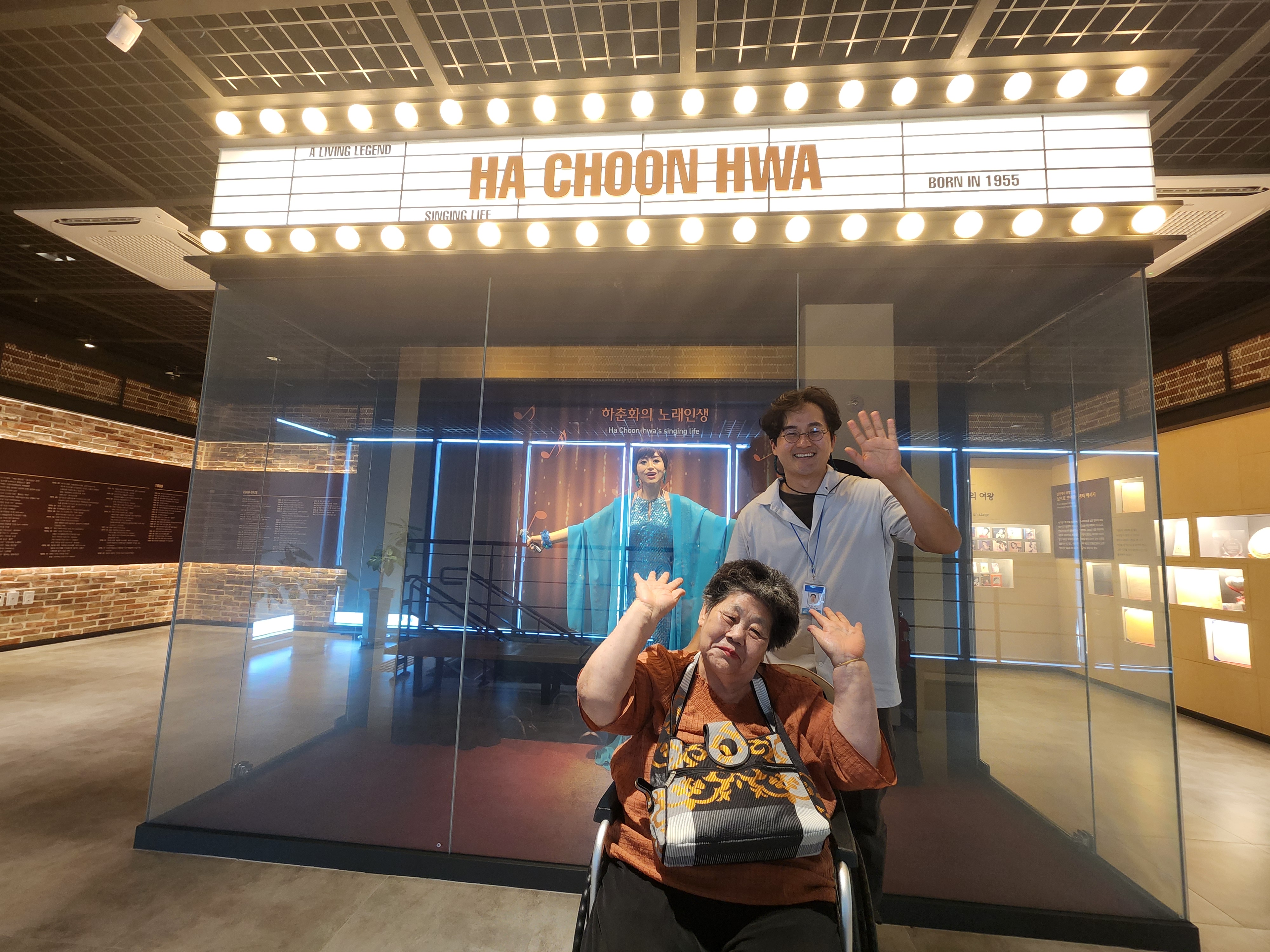 전시물 앞에서 이용인과 담당사회복지사가 함께 찍은 기념사진입니다.