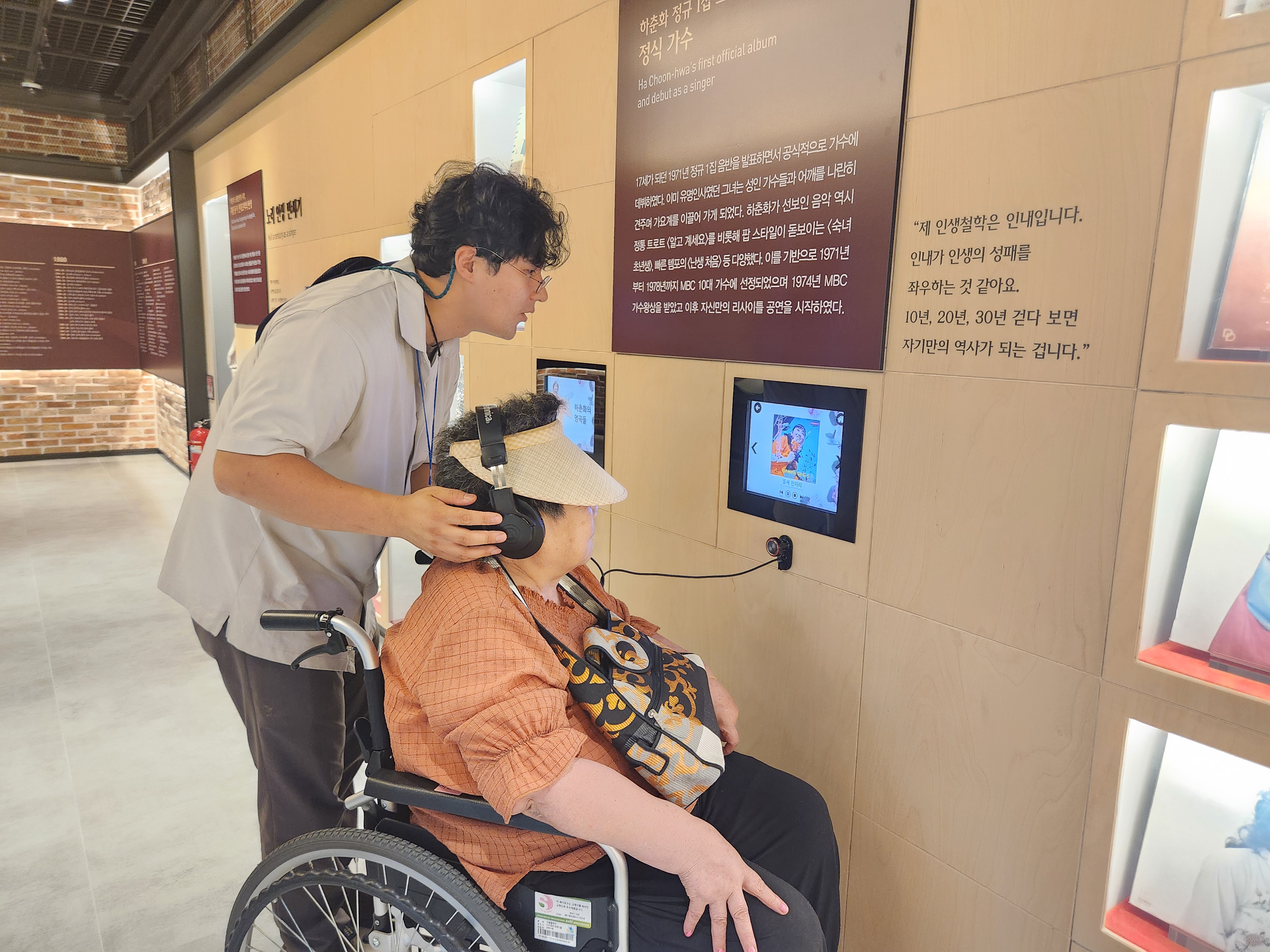 한국트로트센터를 관람하던 중 음악을 들어보고 있는 이용인의 모습입니다.