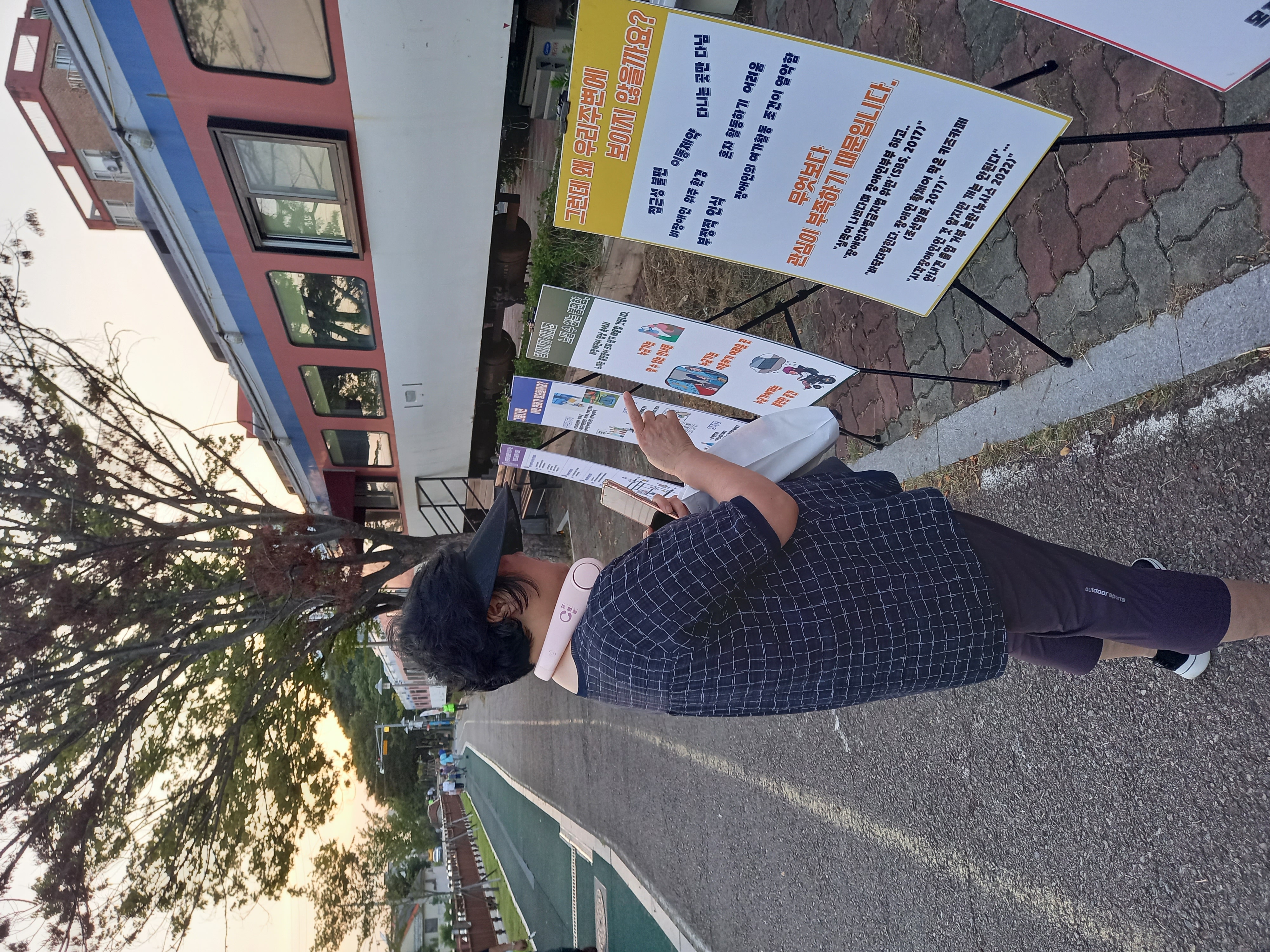 장애인식개선과 관련된 메세지를 담은 게시물을 읽고 있는 지역주민의 모습입니다.