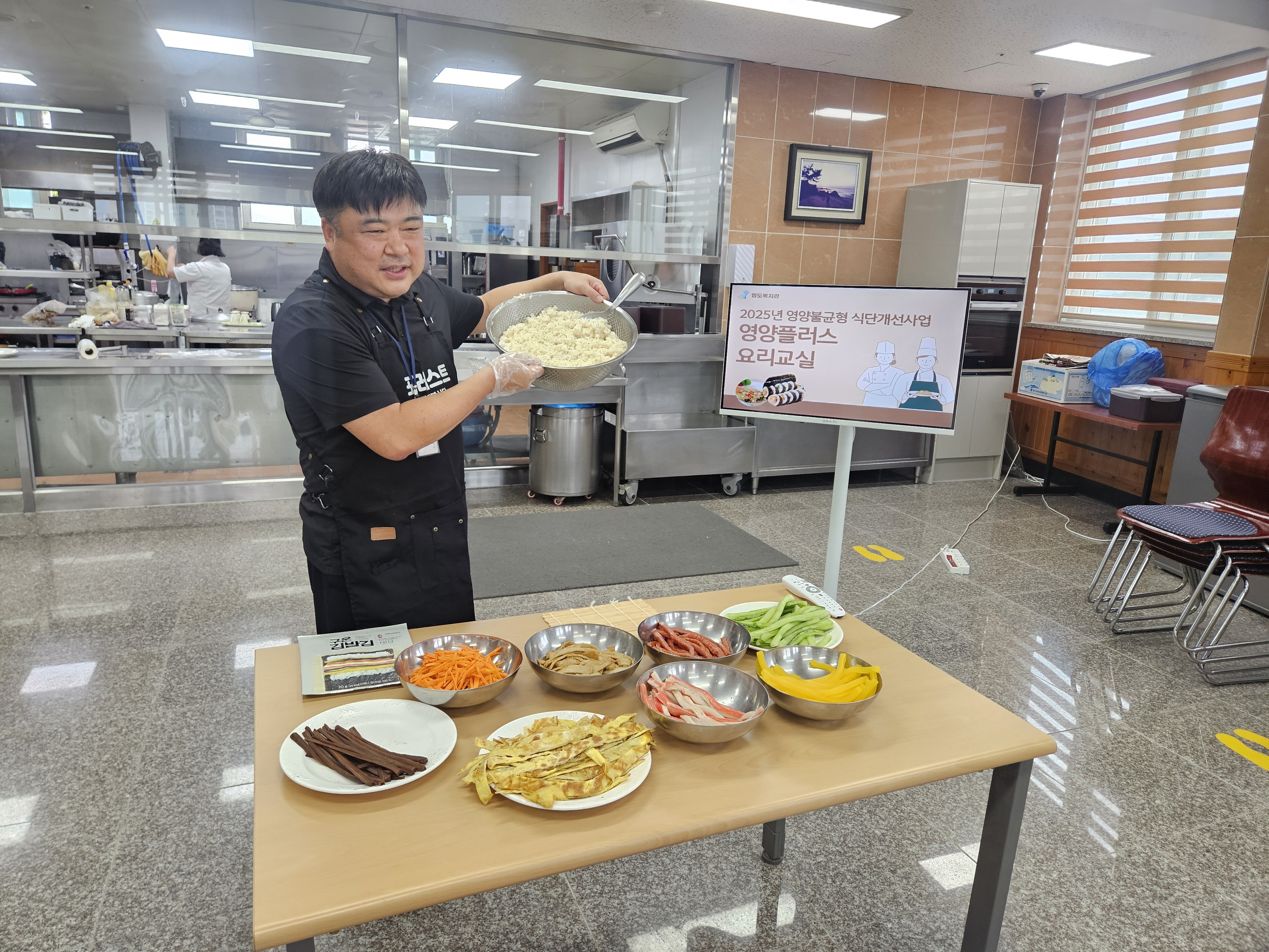 김밥재료를 앞에 두고 김밥을 싸는 방법을 설명하고 있는 담당자의 사진입니다. 