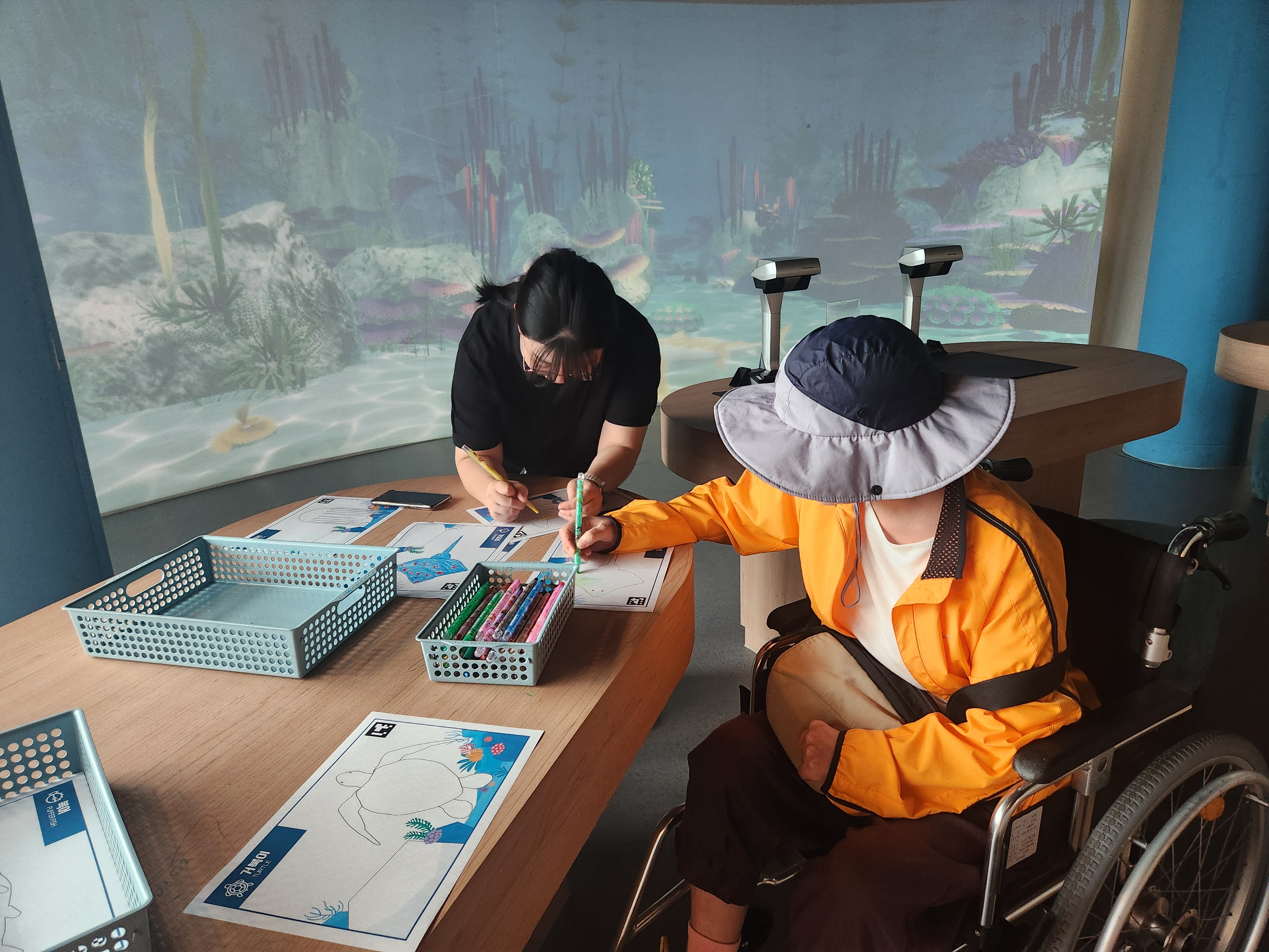 박물관 내 프로그램을 참여하고 있는 이용인과 담당사회복지사의 모습입니다.