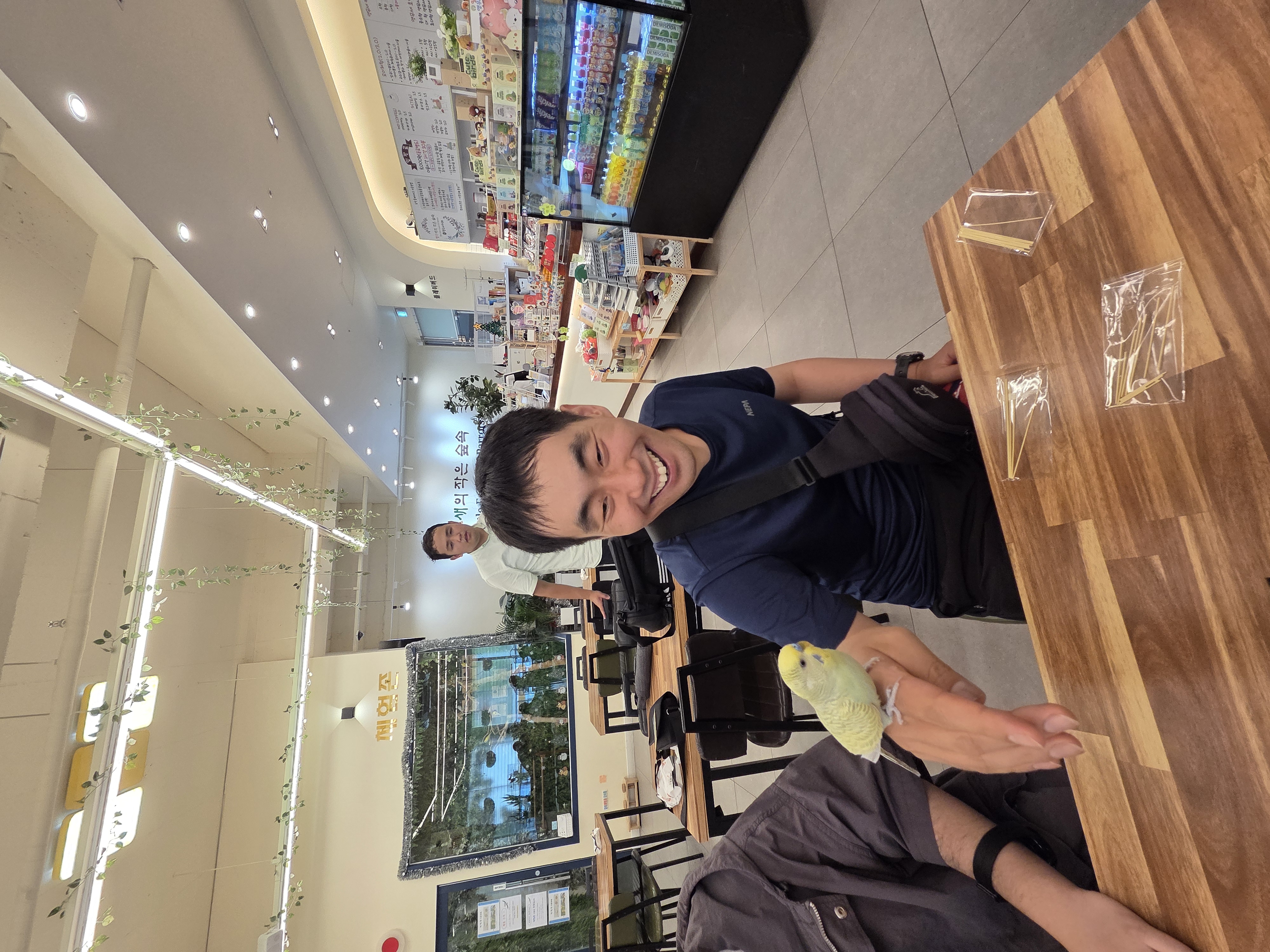 손등에 앵무새를 올리고 즐거워하고 있는 이용인의 사진입니다.