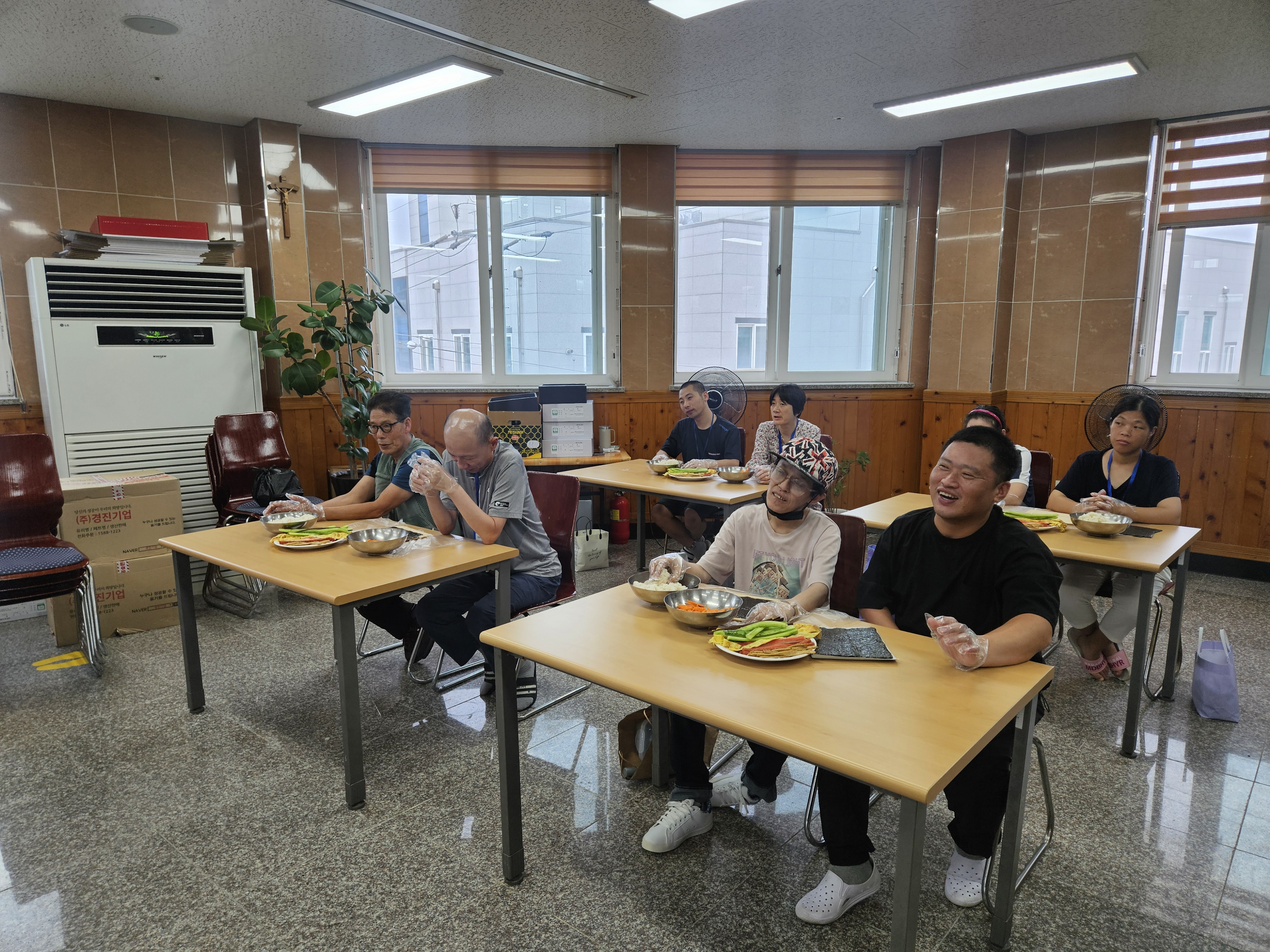 밝은 표정으로 담당자의 설명을 듣고 있는 참여자들의 사진입니다. 