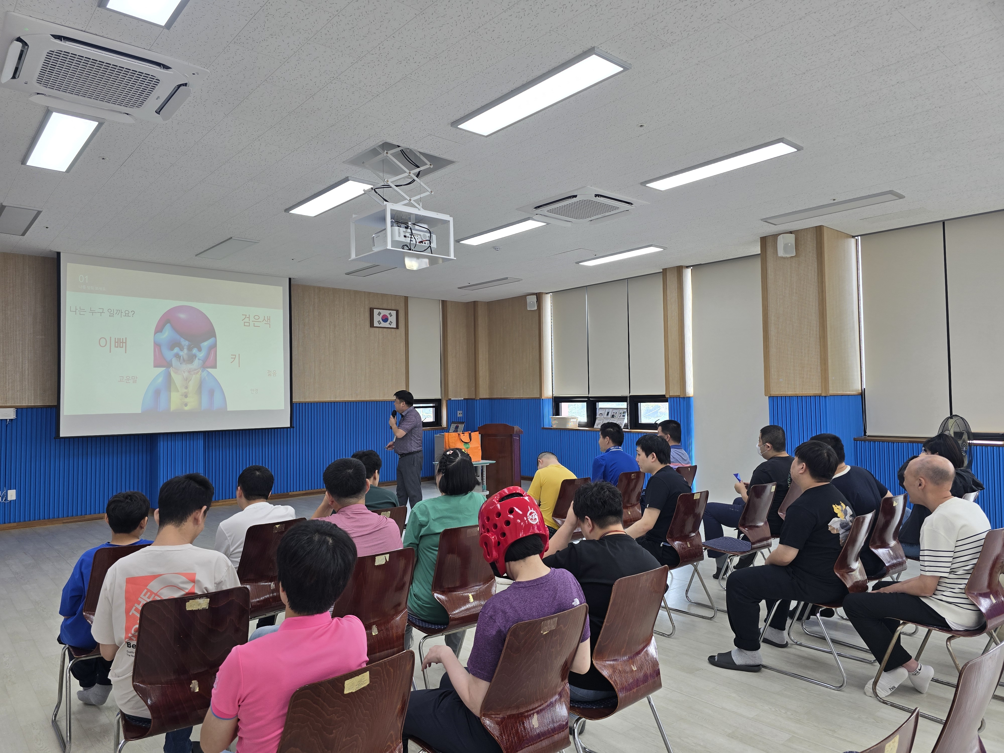 주간보호센터 이용인들이 의자에 차례대로 앉아 강사님의 교육을 듣고 있는 모습입니다.