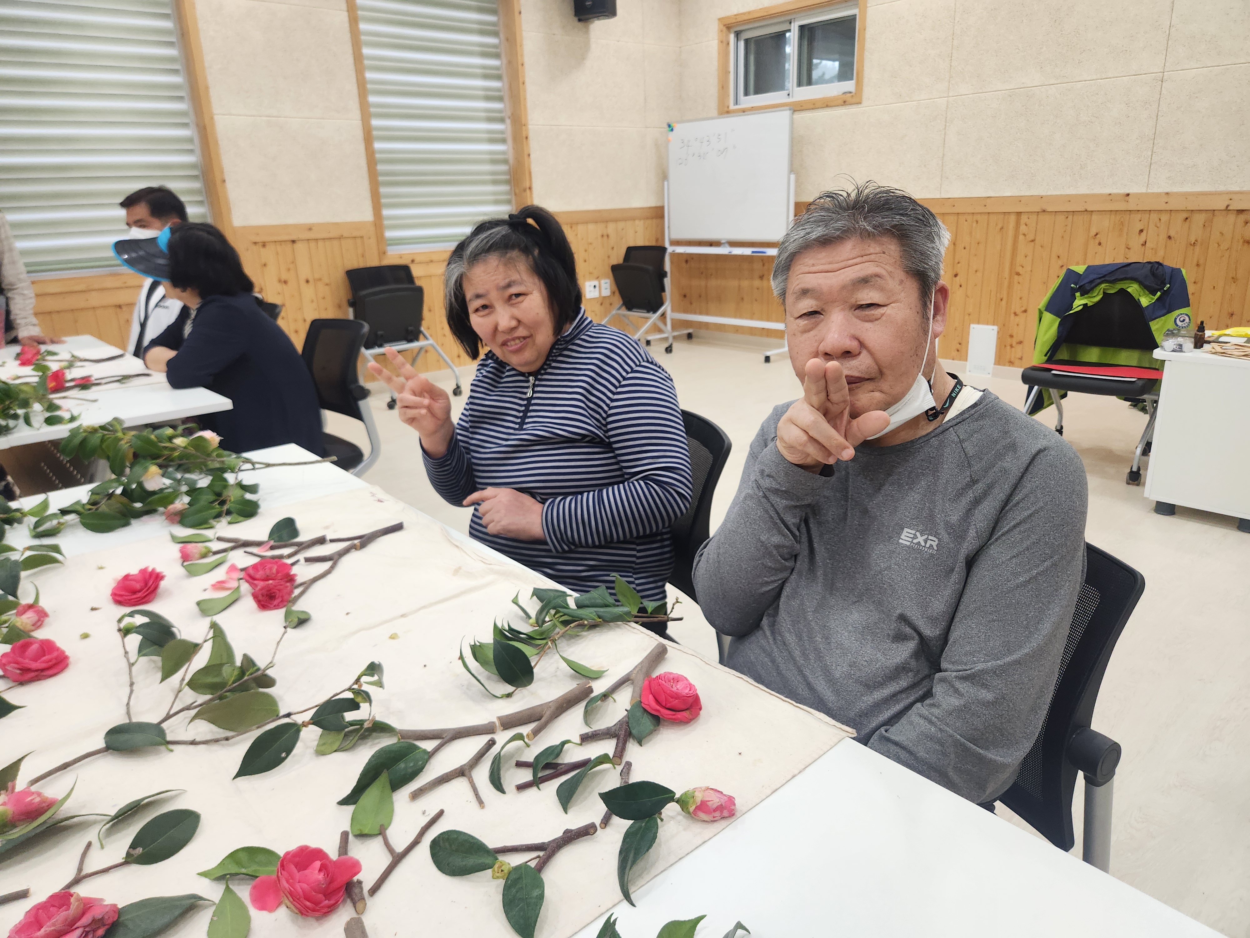 협동하여 나뭇잎과 꽃잎으로 만들기 활동을 하는 모습입니다.