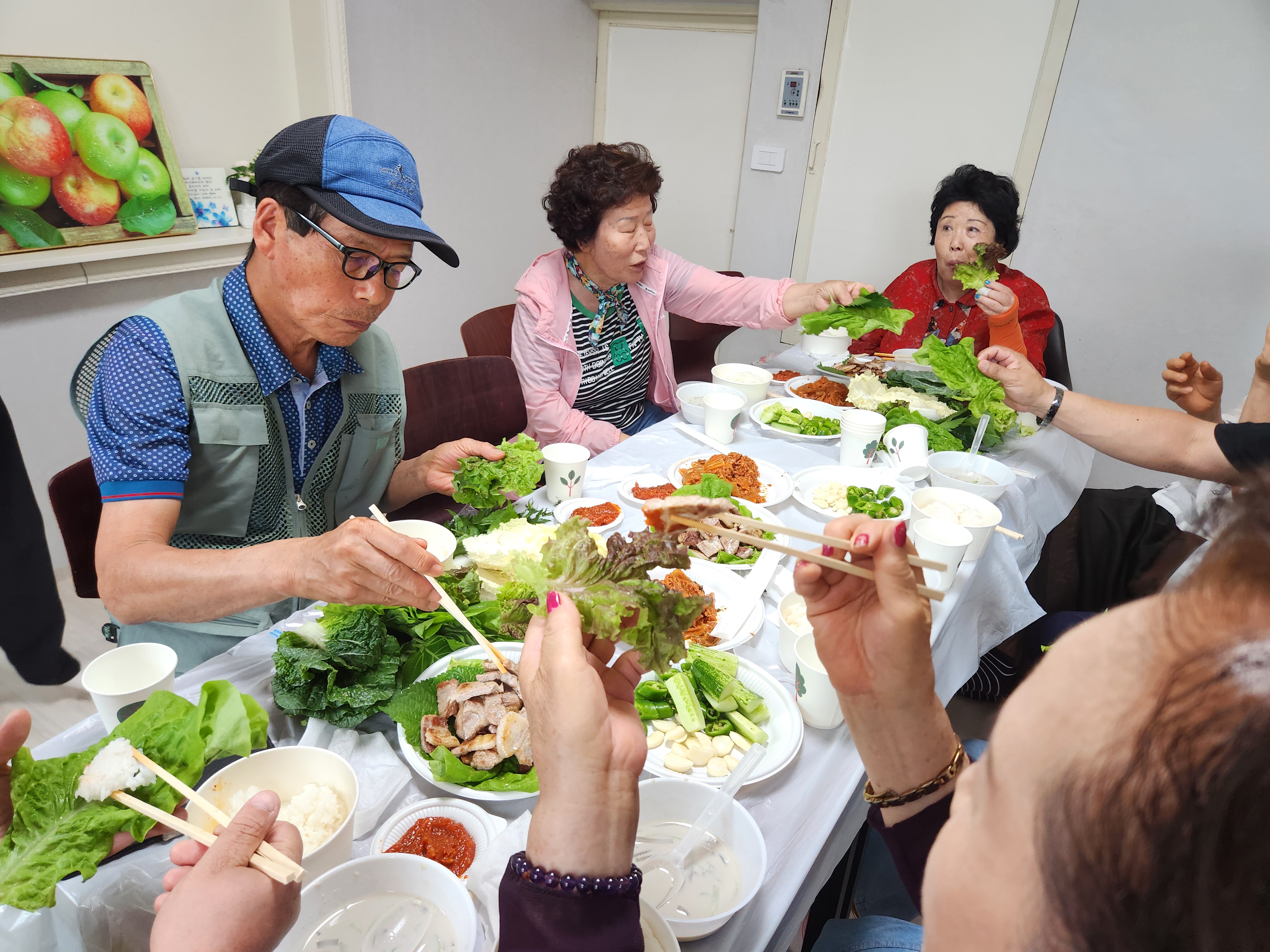 고기를 먹기 전 쌈채소를 들고 식사하는 사진입니다.