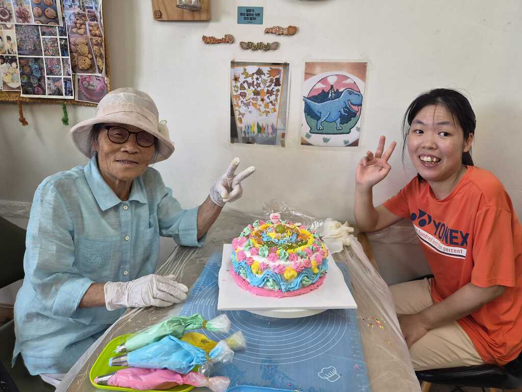 할머니와 손녀가 같이 만든 케이크와 함께 찍은 사진입니다.